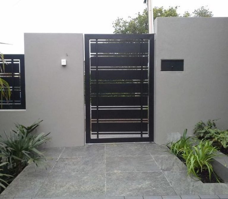 Black metal garden gate with horizontal slat design fitted into a rendered garden wall
