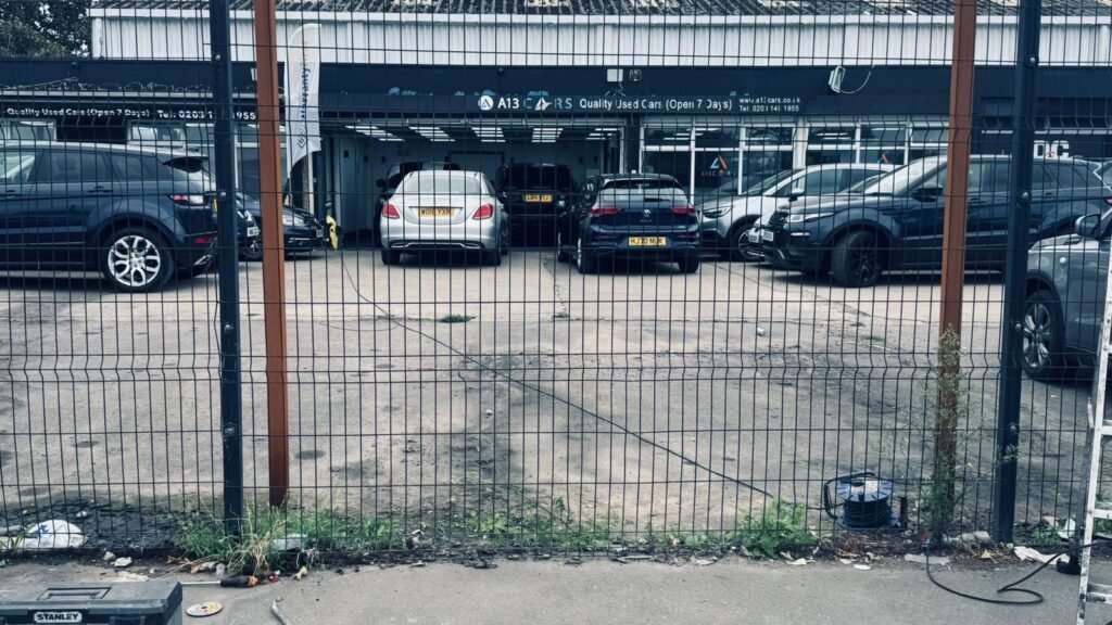 Commercial Security Gate Upgrade for Car Dealership 5 Plain mesh security fencing with no signage outside a used car dealership forecourt