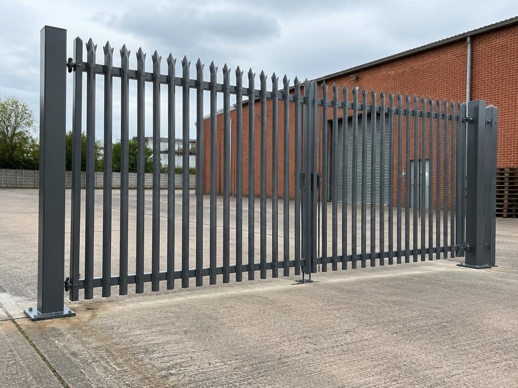 Charcoal commercial double gates with vertical palisade pales at a brick industrial yard